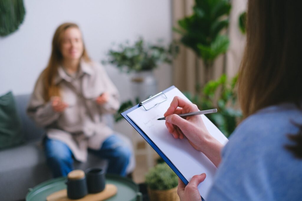 crop psychologist taking notes during appointment