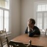 photo of man leaning on wooden table